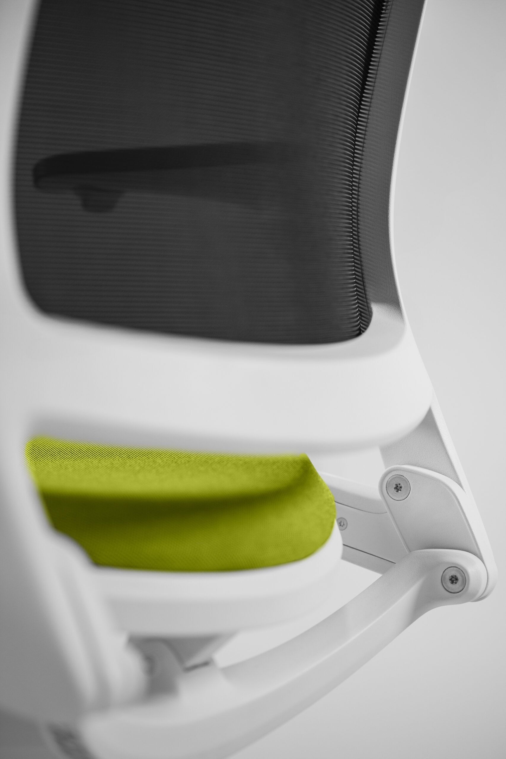 Detal białego fotela biurowego z zielonym siedzeniem od tyłu zdjęcie 11
