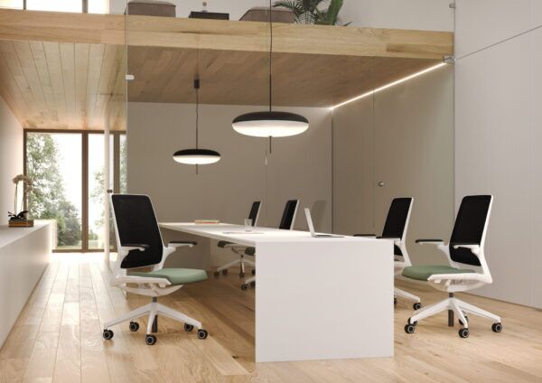Biuro z drewnianą podłogą w którym stoją białe fotele biurowe smart z zielonymi siedziskami przy białym biurku scena 2